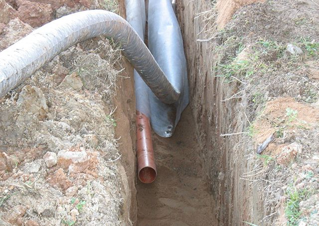 Для минимизации земляных работ на участке канализационные трубы поверхностного дренажа нередко укладывают рядом с дренами в одной траншее