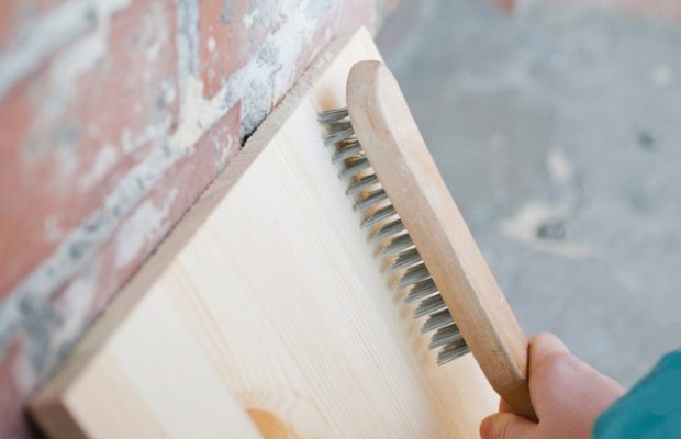 Использование жесткой металлической щетки с ручкой является наиболее простым способом состаривания древесины